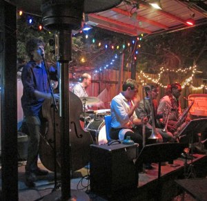 The Roamin' Jasmine performing at Bacchanal. Taylor is on bass (left).